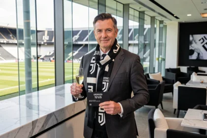 Homme en costume élégant dans le salon VIP d'un stade de football avec un ticket premium Juventus FC
