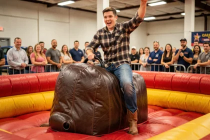 Homme adulte chevauchant un taureau mécanique lors d'une animation de fête en intérieur